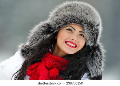 portrait of beautiful smiling female in luxurious fur head cloth outdoor in winter