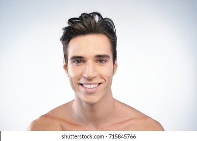 Portrait Of A Beautiful Smiling Man Showing White Teeth Looking Into Camera Or Making Faces Of Doubt Or Blunders With Perfect Skin And Combed Hair.
