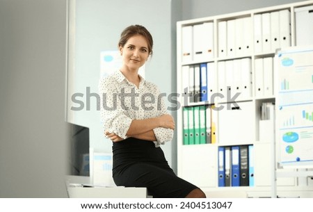 Portrait of beautiful smiling model posing in conference room in office after making important deal. Business and company meeting concept. Blurred background