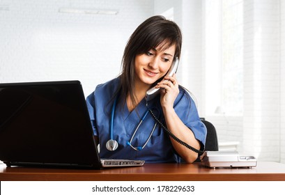 Portrait Of A Beautiful Smiling Nurse Talking On The Phone