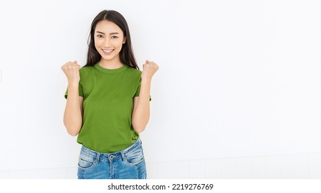 Portrait Of Beautiful Smiling Positive Happy Asian Woman Her Fists Up. Closeup Delight Excited Face Girl Wearing Grey T-shirt. People Lifestyle Successful Triump Victory Panoramic Banner