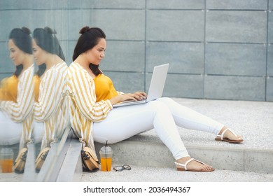 Portrait Of Beautiful And Smiling Stylish Plus Size Business Woman 30-35 Years Old In Yellow Fashion Clothes And Eyeglasses, Working Remotely On A Laptop On Vacation. 