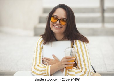 Portrait Of Beautiful And Smiling Stylish Plus Size Business Woman 30-35 Years Old In Yellow Fashion Clothes And Sunglasses, Working Remotely On A Laptop On Vacation. 