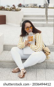 Portrait Of Beautiful And Smiling Stylish Plus Size Business Woman 30-35 Years Old In Yellow Fashion Clothes And Sunglasses, Working Remotely On A Laptop On Vacation. 