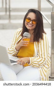 Portrait Of Beautiful And Smiling Stylish Plus Size Business Woman 30-35 Years Old In Yellow Fashion Clothes And Sunglasses, Working Remotely On A Laptop On Vacation. 