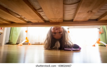 Portrait Of Beautiful Smiling Teenage Girl Looking Under The Bed For Slippers