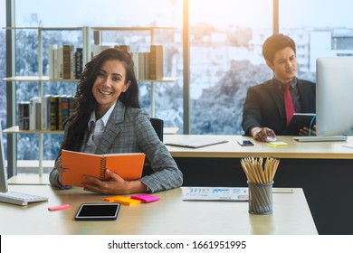 Portrait of beautiful smiling young caucasian business woman sitting at modern workstation, prepare flyer and agenda for presentation in marketing meetings.