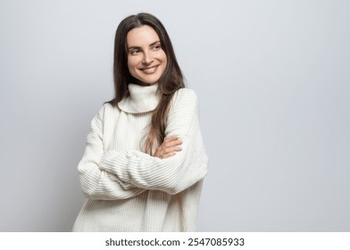 Retrato de una hermosa mujer joven sonriente con un suéter blanco, sobre fondo gris claro.