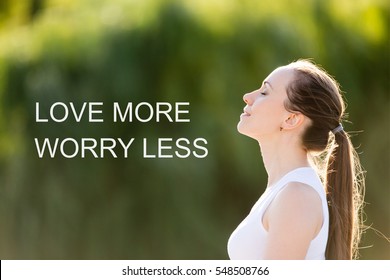 Portrait of beautiful smiling young woman enjoying yoga, relaxing, feeling alive, breathing fresh air, got freedom, dreaming with closed eyes. Photo with motivational text "Love more worry less"