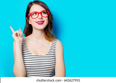 portrait of beautiful smiling young woman in glasses on the wonderful blue studio background - Shutterstock ID 642627955