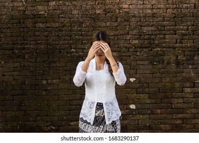 Portrait Of Beautiful South East Asian Woman Wearing Jewelry And White Traditional Cloth With Brick Wall Background.Calm Face Expression Medium Close Up Photography,