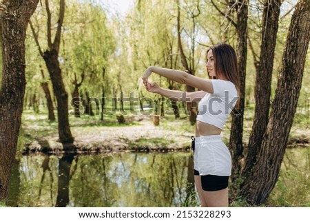 Portrait of a beautiful sports woman stretching legs outdoors