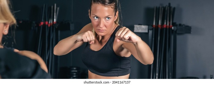 Portrait of beautiful sportswoman training hard boxing in the gym - Powered by Shutterstock