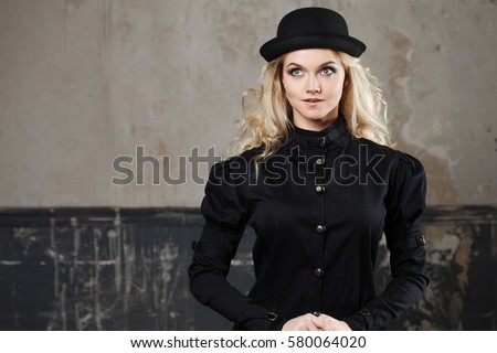 Portrait of a beautiful steampunk woman hat-bowler hat over grunge background.