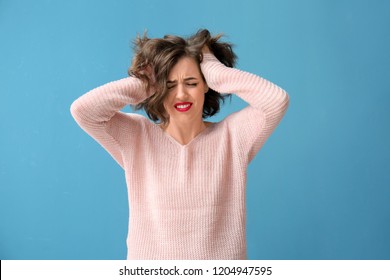 Portrait of beautiful stressed woman on color background