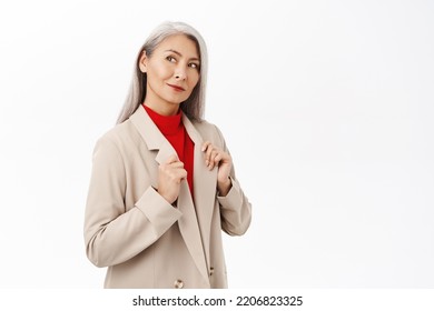 Portrait Of Beautiful And Stylish Senior Asian Businesswoman, Corporate Korean Woman Looking Confident And Professional, Standing Over White Background.