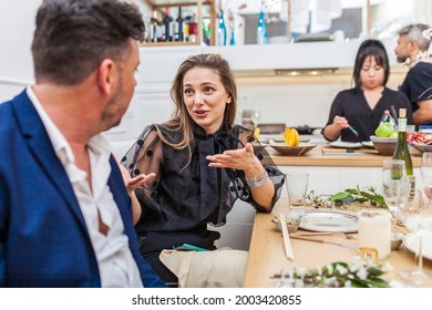 Portrait Of A Beautiful Stylish Woman Conversating With A Friend At A Private Dinner Party While The Chefs Are Cooking