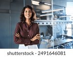 Portrait of beautiful successful hispanic young business woman with crossed arms smiling confident at camera. Latin or eastern middle age female ceo leader businesswoman standing in office. Copy space