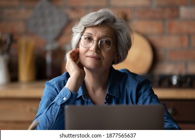 Portrait Of Beautiful Thoughtful Middle Aged Businesswoman In Eyeglasses Working On Computer At Home Office. Pensive Pleasant Attractive Older Mature Woman In Glasses Looking At Camera, Working Online