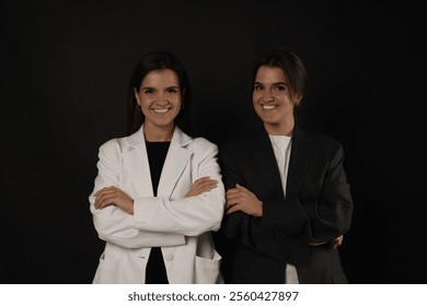 Portrait of beautiful twin sisters on black background - Powered by Shutterstock