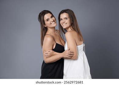 Portrait of beautiful twin sisters on grey background - Powered by Shutterstock