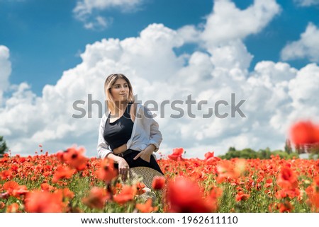 portrait of beautiful ukrainian woman with blond hair, wearing white blouse, posing in poppy field at sunny day, lifestyle