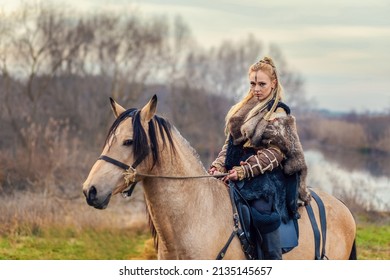 Portrait Of Beautiful Viking Woman Warrior With Painted Face And Braids Riding Horse In Forest