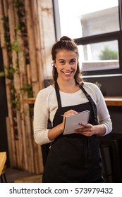 Portrait of beautiful waitress taking order in cafeteria