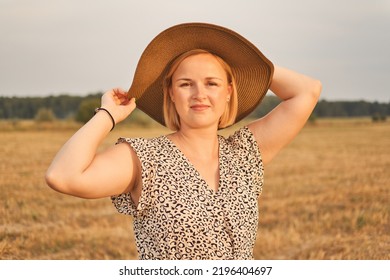 Portrait Of Beautiful White European Woman In Dress And Hat At Evening Time Outdoors.