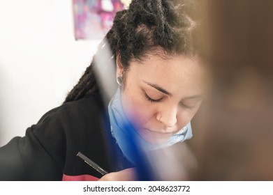 Portrait Of Beautiful White Girl Hispanic Latin Art Director, With Dreadlocks And A Pencil, Eyes Closed And Concentrated, Working On Her Work Table, In Her Artistic Production Workshop.