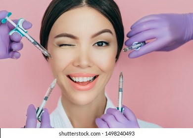 Portrait of a beautiful winking woman and many syringes with beauty injections around her face - Shutterstock ID 1498240493