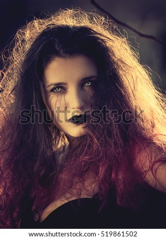 Portrait of a beautiful  witch with red hair and scary eyes 