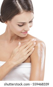 portrait of beautiful woman applying body lotion to her arms isolated on white background
