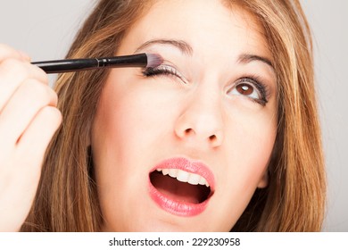 Portrait Of A Beautiful Woman Applying Eye Shadow