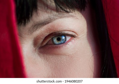 Portrait Of Beautiful Woman Behind A Red Curtain, Close Up Blue Eye