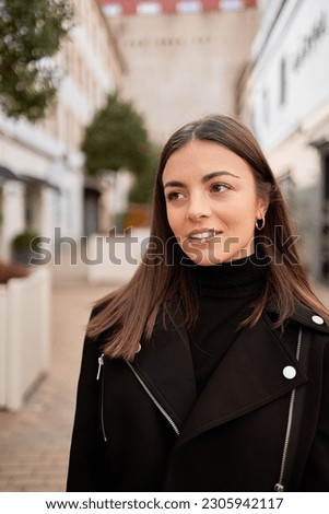 portrait of a beautiful woman with brown hair and black jacket in exterior