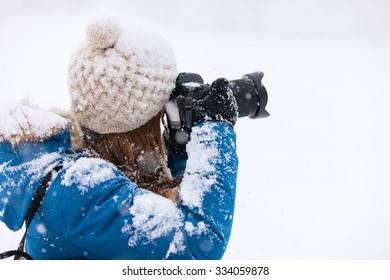 Portrait of beautiful woman with camera on winter snow day - Powered by Shutterstock