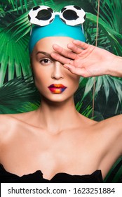 Portrait Of Beautiful Woman With Colorful Make Up, Beauty Magazine Editorial Ready, Caucasian Girl, With Swimming Hat, Sunglasses And Tropical Exotic Background