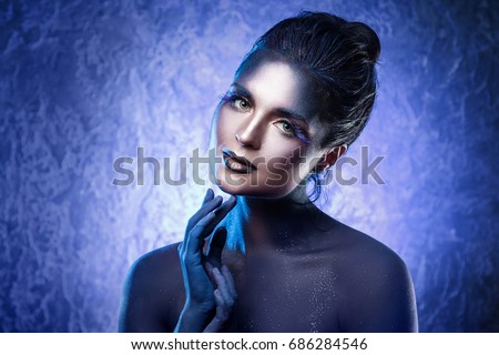Portrait of beautiful woman with a creative makeup and body-art