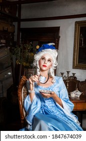 Portrait Of A Beautiful Woman Dressed In Baroque Style, Drinking Tea From A Beautiful Cup. Photo For The Cover Of A Historical Romance Novel