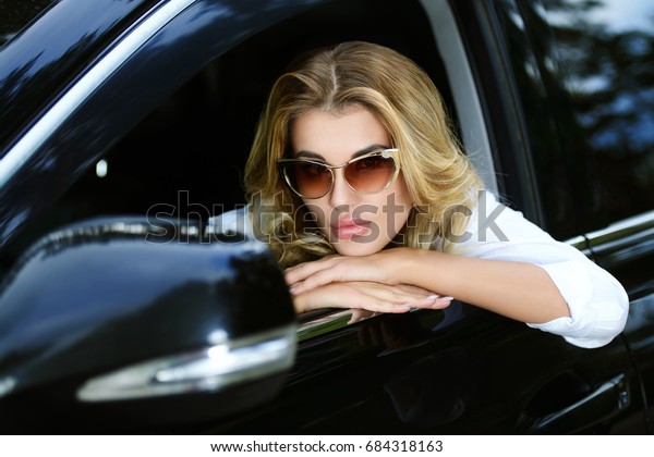 Portrait of a beautiful woman driving a car.\
Beauty, fashion. Outdoor summer\
portrait.