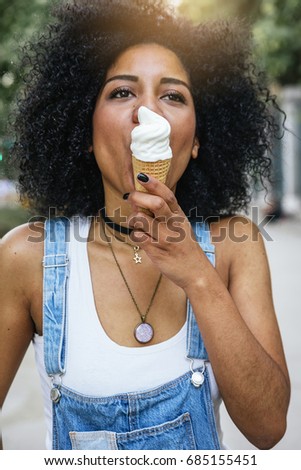 Portrait of a beautiful woman eating one ice cream in the street.