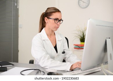 Portrait Of A Beautiful Woman Female Doctor In Medical Practice Office Working On Computer