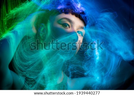 Beautiful young woman posing with blue makeup