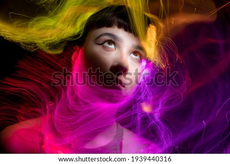 Similar – Artistic portrait of a brunette woman with a light effect