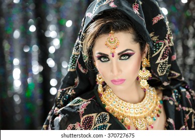 Portrait of a beautiful woman in glamorous outfit and jewellery with makeup