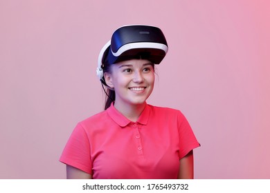 Portrait of beautiful woman in glasses of virtual reality. Augmented reality, future technology concept. VR. Pink background. Free space for text.