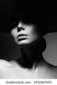 portrait of Beautiful Woman in Hat. Beauty female face in shadow