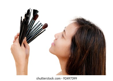 portrait of beautiful woman holding makeup brushes