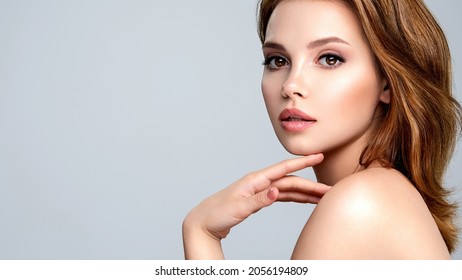Portrait of a beautiful woman with a long brown hair. Pretty young adult girl is looking at camera.